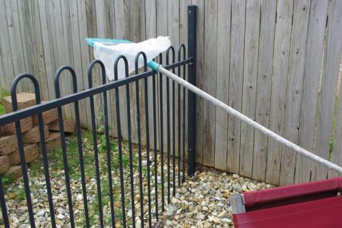 Metal pool fence buried in decorative gravel resulting in overall height of less than 1200mm